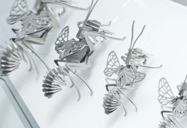 Aufreihung von verschieden großen Bienenmodellen aus Metall, die im Laserschneidverfahren gefertigt wurden